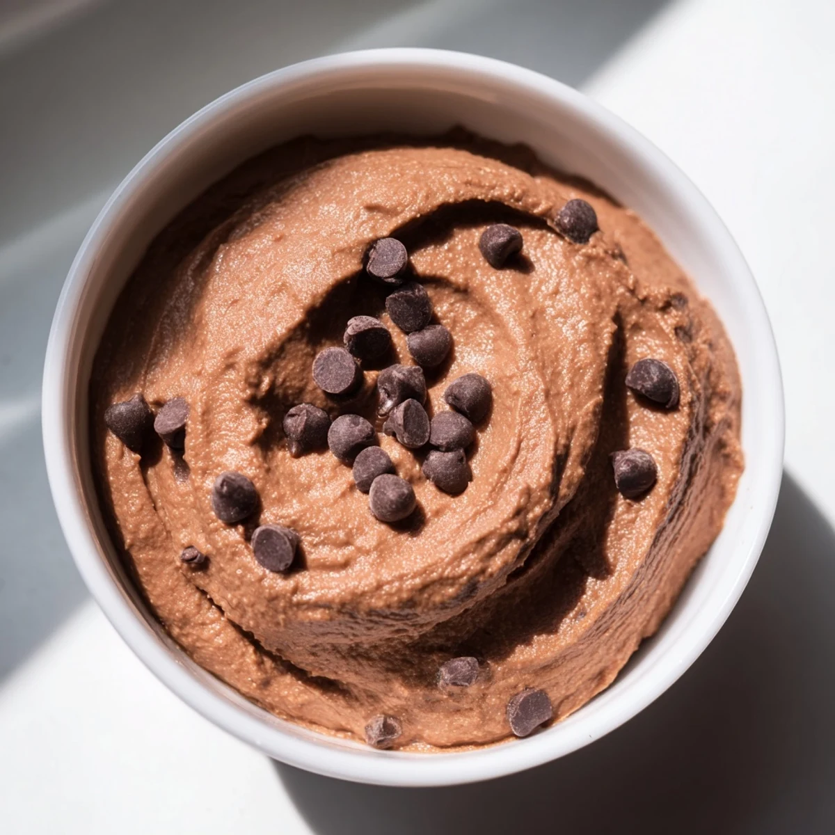 Smooth and creamy Chocolate Hummus, a perfect dip, served with fresh strawberries for a delicious treat.