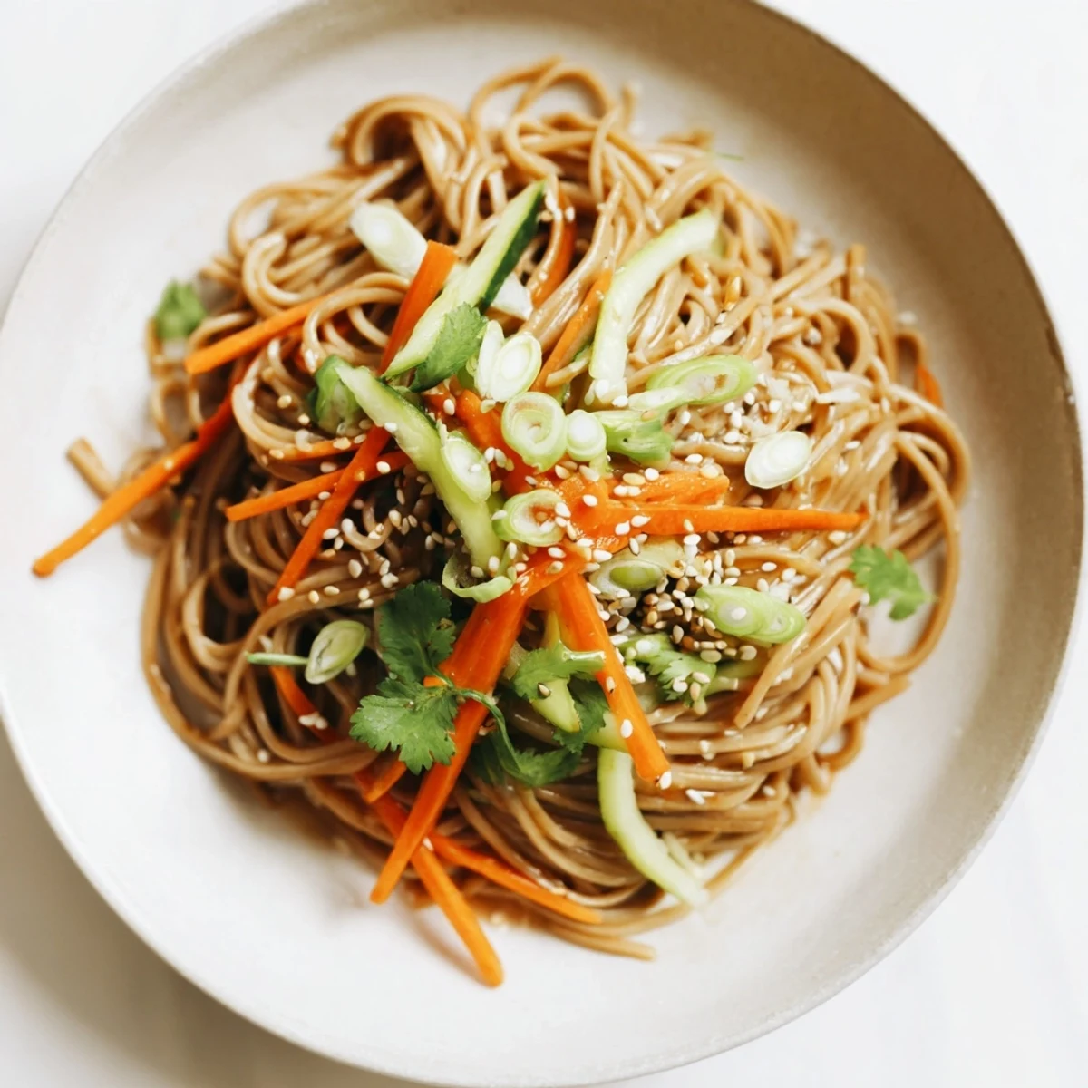 These Chilled Noodle Lunch Cups showcase perfectly chilled soba noodles glistening with sesame oil and fresh garnishes, ready to eat.