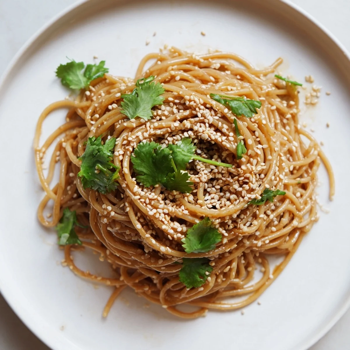 Spicy Sesame Noodle Salad served cold with julienned cucumber, fresh cilantro, and toasted sesame seeds for crunch.