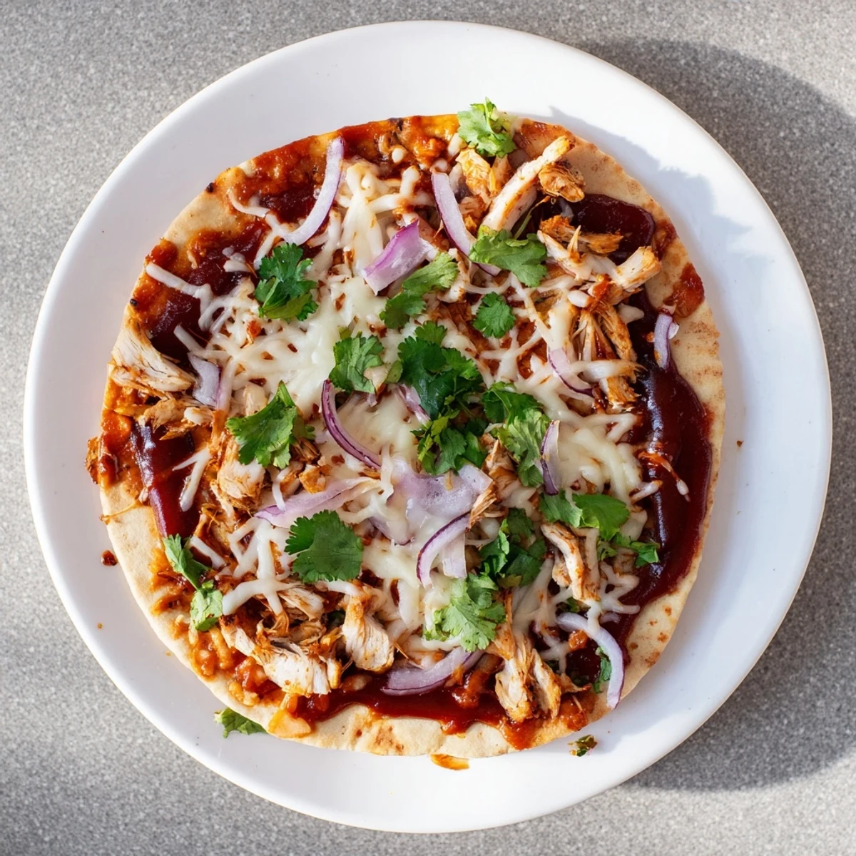 Golden-brown BBQ Chicken Flatbread fresh from the oven, featuring bubbling mozzarella, tender grilled chicken, and sweet red onion slices on a crispy crust.