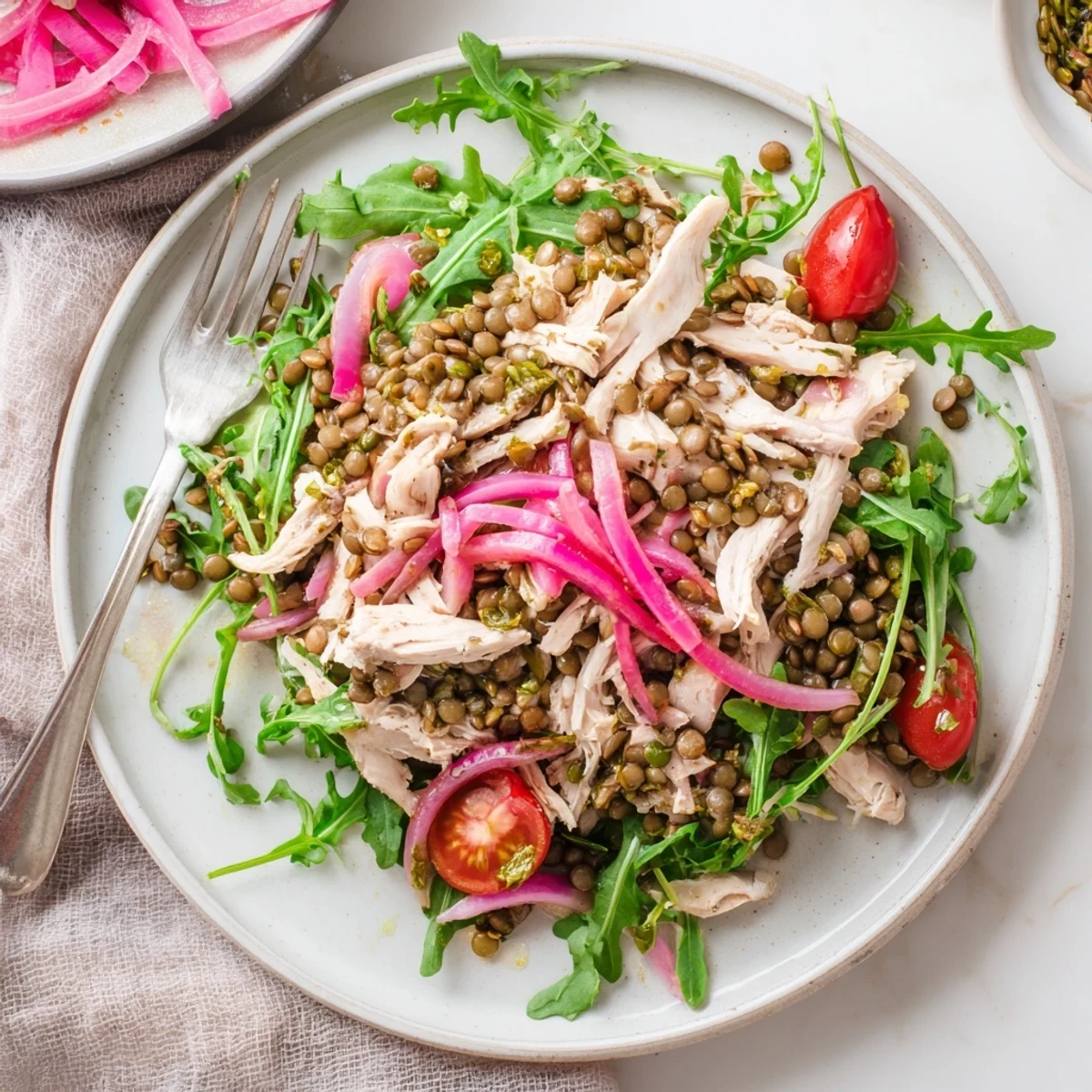 Vibrant Lentil & Chicken Spring Salad on a rustic wooden table, with bright greens and tangy pickled onions perfect for a light lunch.