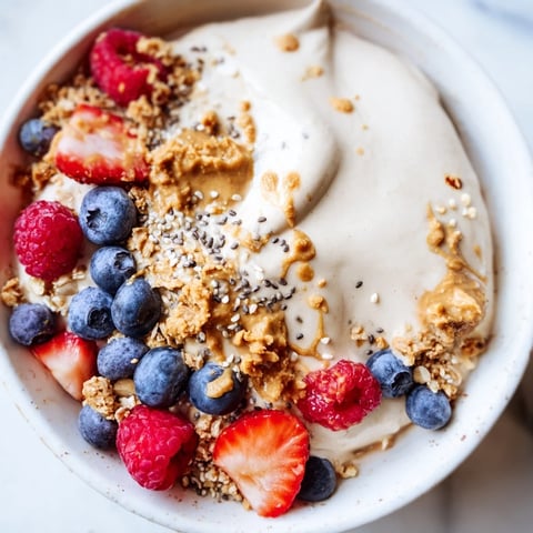 Delicious, creamy protein ice cream bowls topped with berries, a healthy and easy dessert.