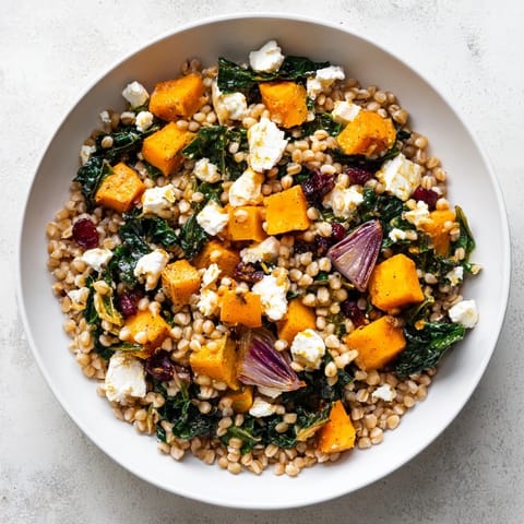 This Harvest Grain Bowl with Roasted Pumpkin and Kale features warm, nutty grains topped with savory vegetables and dressing.