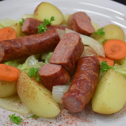 Sizzling close-up of a pan of All-in-One Sausage and Cabbage Bake, with a delicious, roasted aroma.