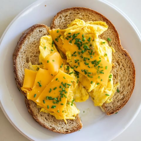 Perfectly cooked One-Pan Egg Breakfast Sandwich, showcasing soft eggs nestled between toasted, golden bread slices.