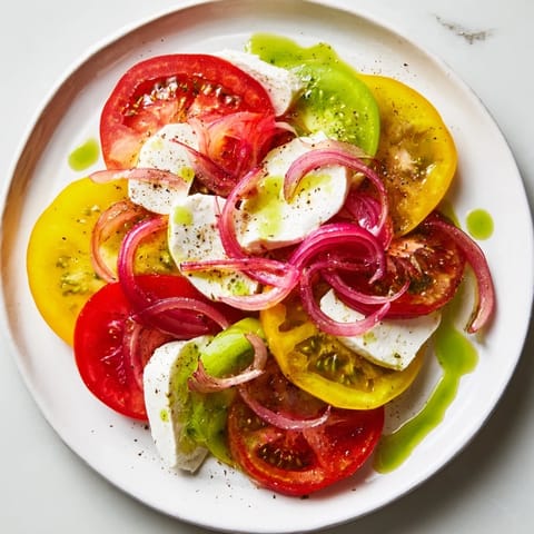 Heirloom tomatoes and fresh mozzarella shine in this Summer Tomato Salad, drizzled with basil oil.