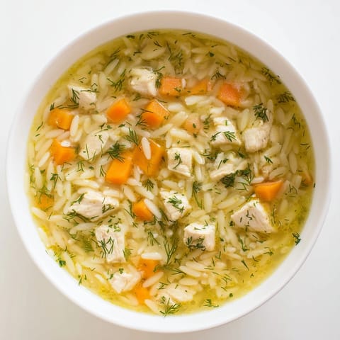 Hearty Chicken Lemon Orzo Soup served with crusty bread, showcasing tender vegetables and golden orzo pasta.  