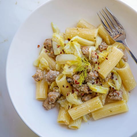 Winter Pasta with Sausage and Fennel served in a rustic bowl, garnished with bright green fennel fronds and shaved Parmesan.