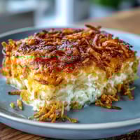 Golden baked cheesy hash brown casserole with crispy cornflake topping and bubbling cheese.